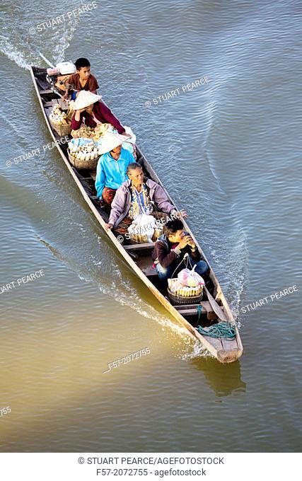 Lao people taking rice to market on the river in Paske, Laos