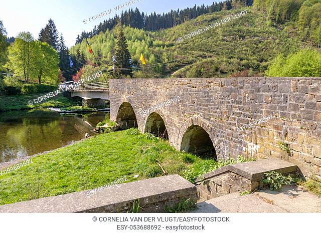 The historical bridge over the river Ourthe in the village Maboge near La Roche-en-Ardenne in Belgium. It is a sunny day during early spring