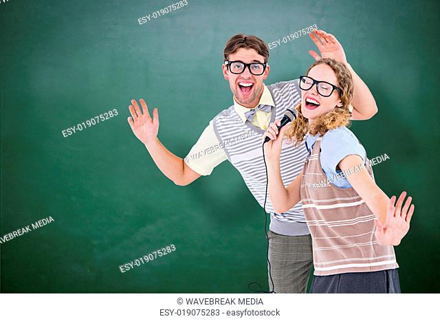 Composite image of geeky hipster couple singing into a microphone