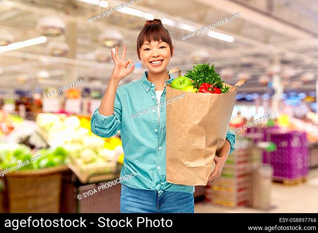 happy asian woman with food in paper shopping bag