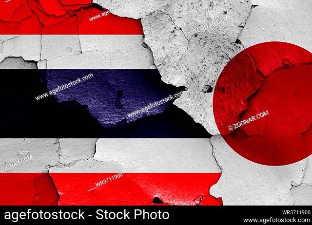 flags of Thailand and Japan painted on cracked wall