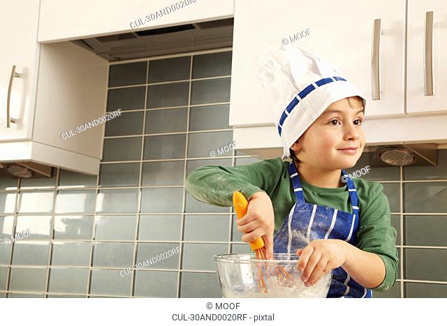 Young boy with mixing bowl in kitchen