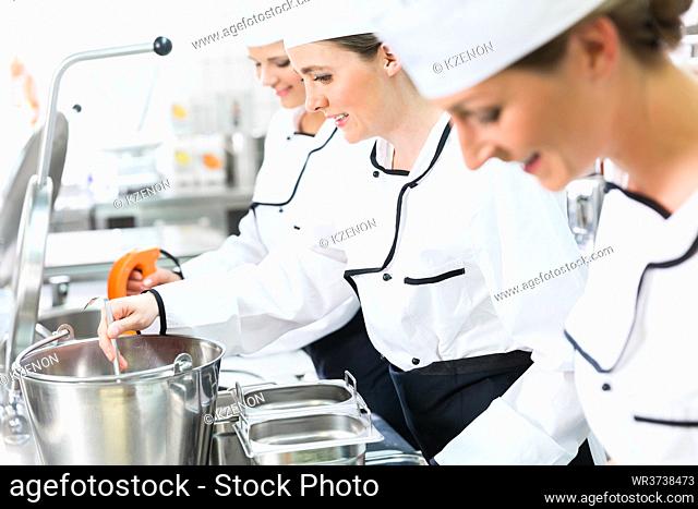 Team of happy chefs in production process of system catering