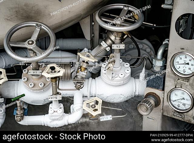 29 September 2021, Schleswig-Holstein, Brunsbüttel: The valves of the connections for LNG refuelling iced up on a tanker in the Elbe port during the refuelling...