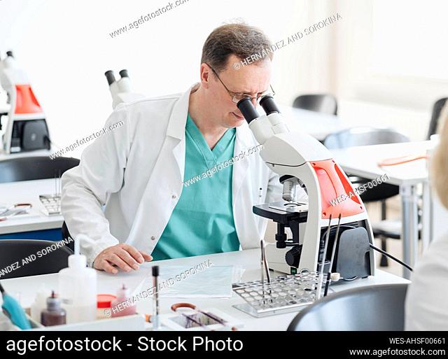Senior researcher working with microscope in lab