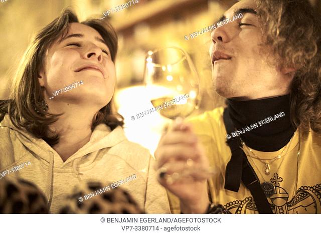 joyful couple with glass of wine in restaurant