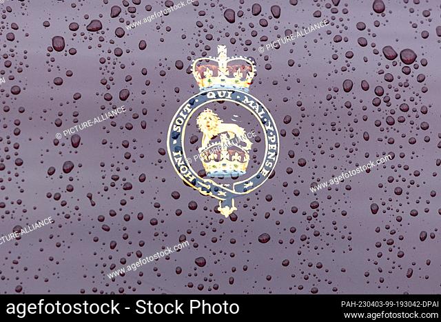 31 March 2023, Hamburg: A royal coat of arms is seen on the Bentley State Limousine, the state coach of the British monarchs, in the rain at the port of Hamburg