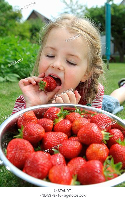 Girl with strawberries in a colander