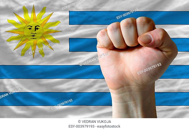 Hard fist in front of uruguay flag symbolizing power