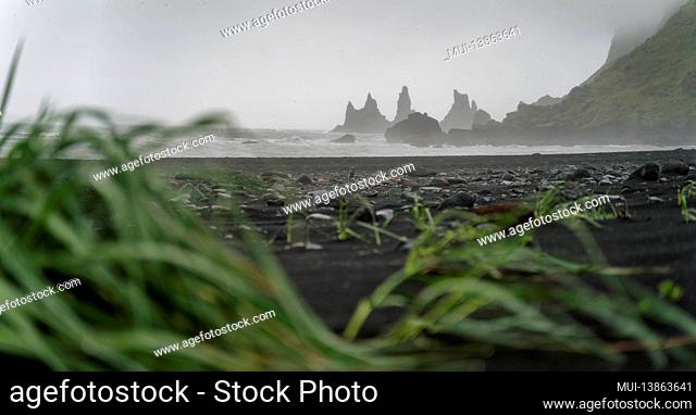 Reynisfjara black sand beach and Reynisdrangar basalt sea stacks on story day, Vik, Iceland