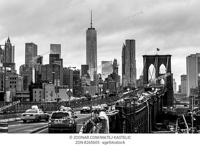 New York City, United States of America - March 25: Traffic on Brooklyn bridge and New York City Manhattan downtown skyline at dusk with skyscrapers over East...