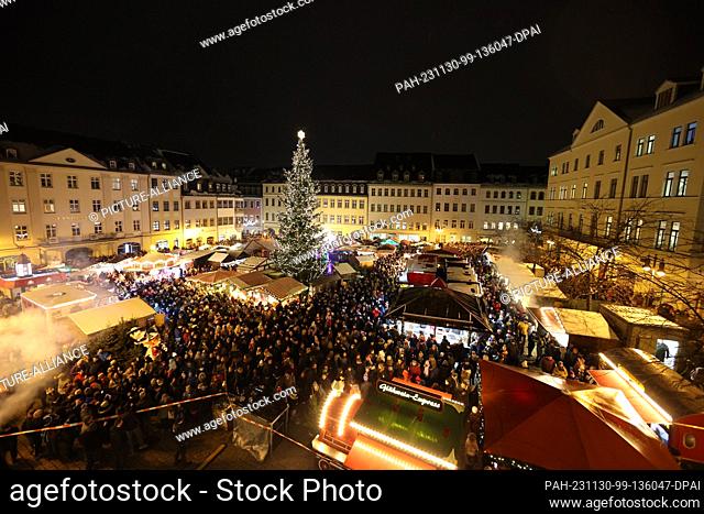 30 November 2023, Thuringia, Gera: Visitors stand on the market square at the opening of the Christmas market. A total of 38 handmade
