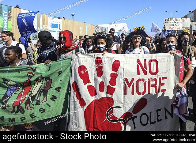 12 November 2022, Egypt, Sharm El-Sheikh: Climate activists hold banners as they take part in the COP27 Coalition march during the 2022 United Nations Climate...