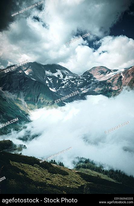 high alpine landscape with peaks covered by snow and clouds in the alps in austria