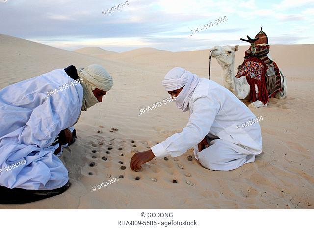 Bedouins playing with stones in the sand, Douz, Kebili, Tunisia, North Africa, Africa