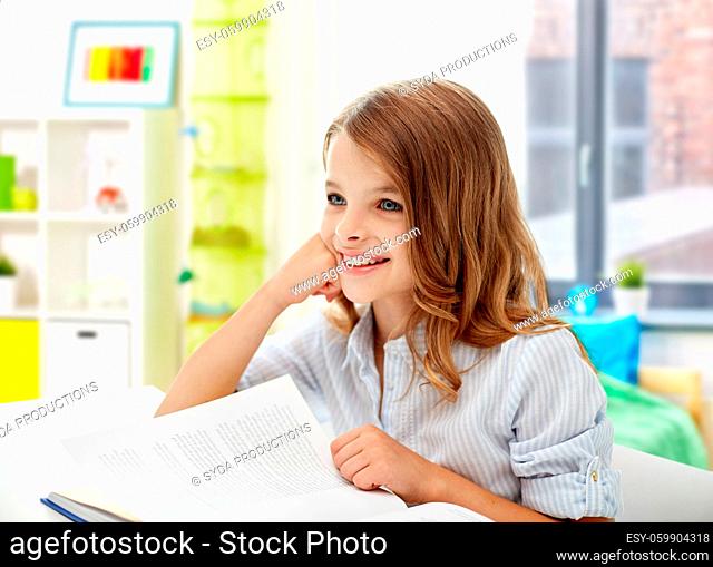 smiling student girl with book learning at home