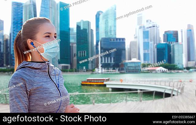 woman in mask with earphones over singapore city