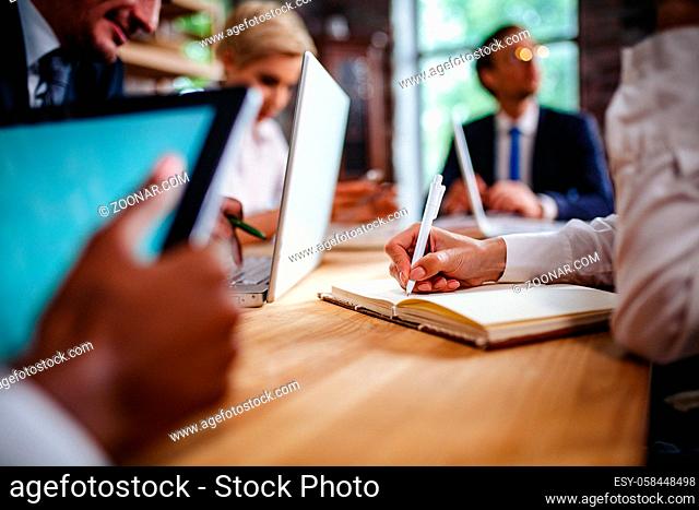 Selective Focus On Woman Hand Writing In Notebook At The Business Meeting. Business Concept