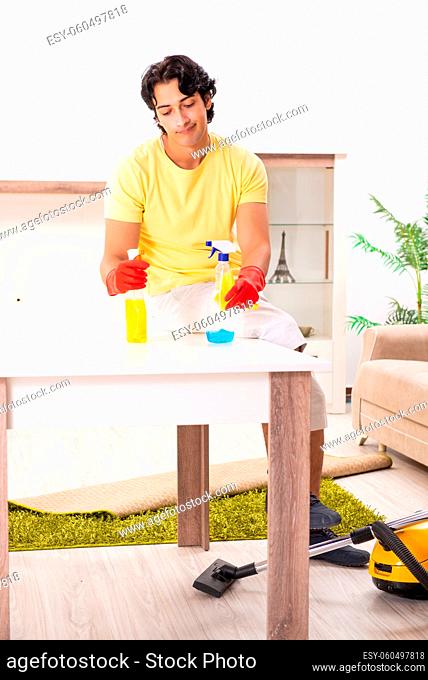 Young handsome man doing housework