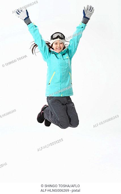 Young Japanese woman wearing snowboard wear on white background