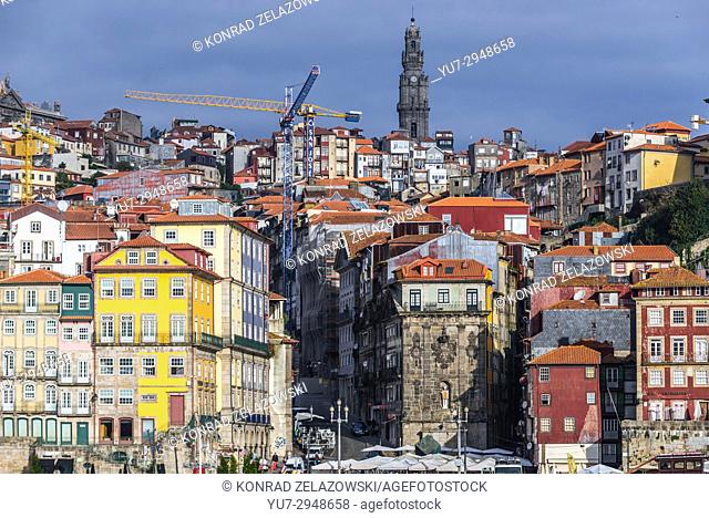 Row of buildings on the Douro riverfront in Porto city, Portugal. View with bell tower of Clerigos Church