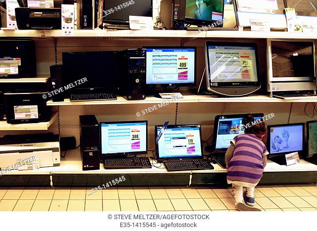 A little girl plays with computers at a department store in Beziers, France