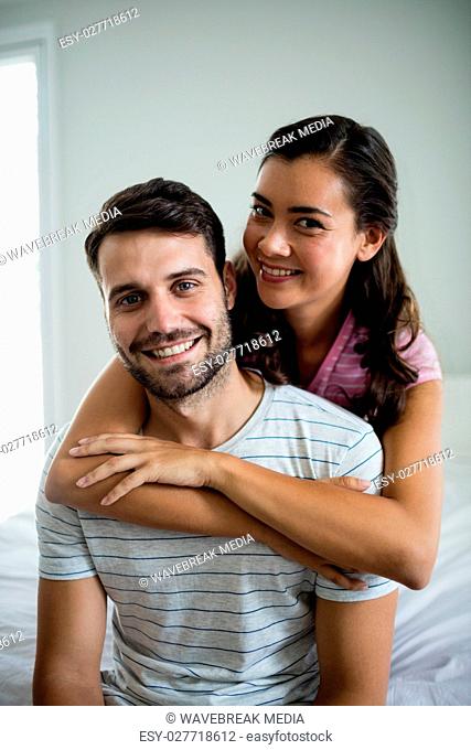 Portrait of couple embracing each other in bedroom