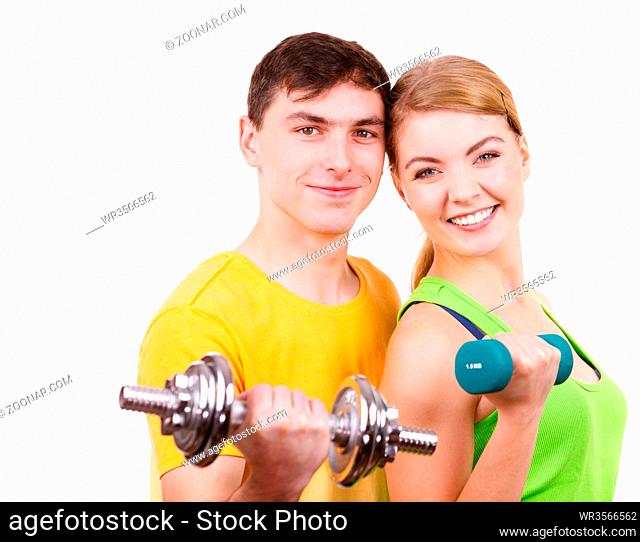 Couple fit woman and strong man exercising with dumbbells. Muscular guy and fitness blonde girl lifting weights. Bodybuilding