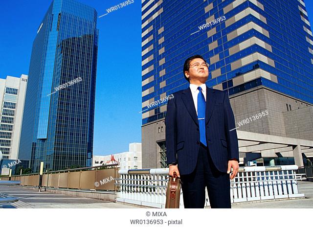 Mature man in suit standing in front of buildings
