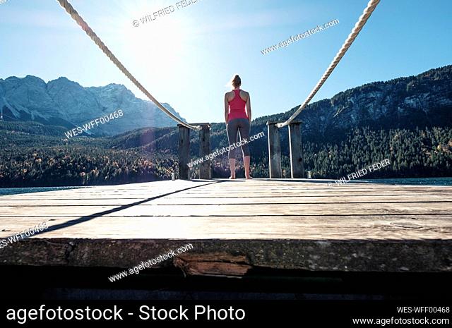 Woman standing on pier during sunny day
