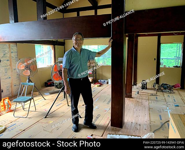 PRODUCTION - 17 July 2022, Japan, Matsudai: German architect Karl Bengs stands next to support beams from an old country house