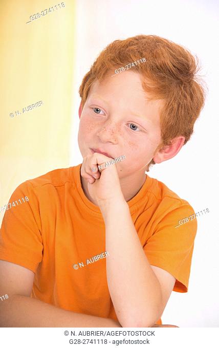 6 year old boy sitting at home thoughtful