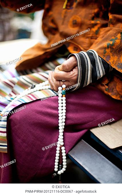 Close-up of a woman's hand holding prayer beads, Tibetan Monastery, Delhi, India