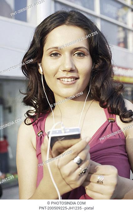 Portrait of a young woman listening to an MP3 player