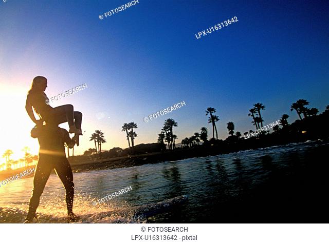 A couple tandem surfing in silhouette Ventura California USA