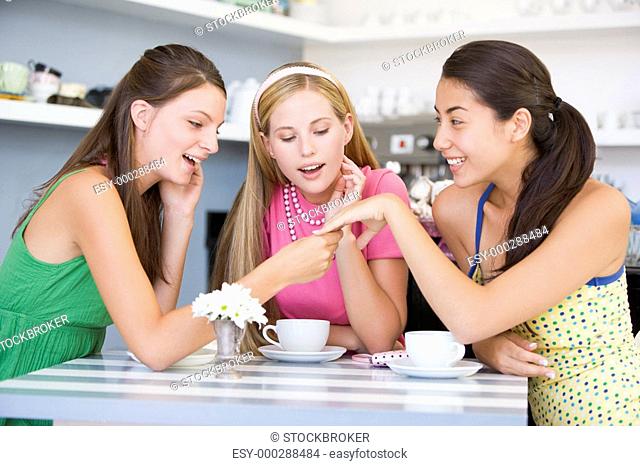 Young woman showing off engagement ring to friends