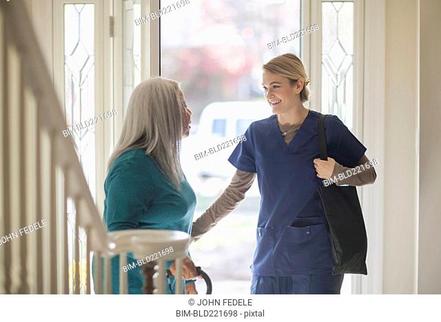 Nurse talking to patient in front door