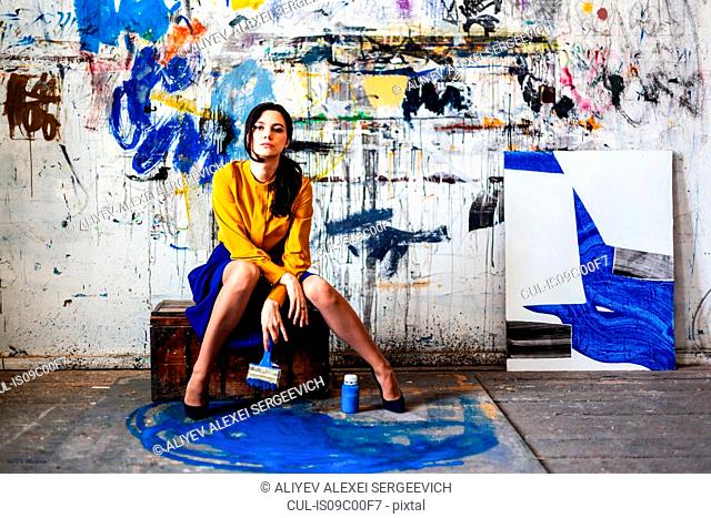 Woman posing in front of wall with graffiti