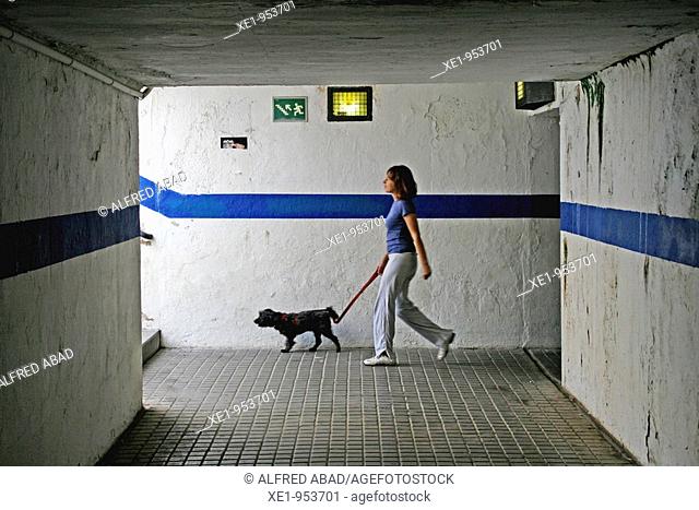 A woman walking the dog through the underpass, El Masnou, Barcelona province, Catalonia, Spain