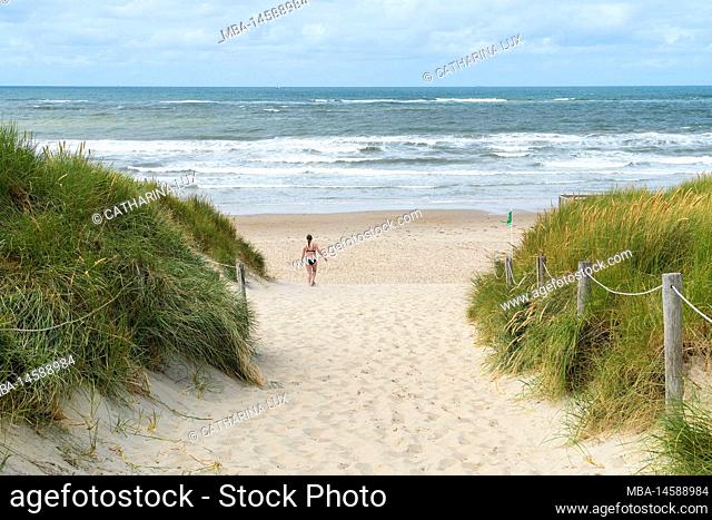 Netherlands, Texel, west coast, bathing beach near De Koog, young woman in bikini running towards water
