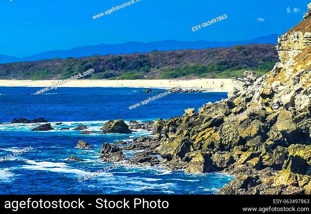 Beautiful rocks cliffs stones and boulders and huge big surfer waves and natural panorama view on the beach in Bacocho Puerto Escondido Oaxaca Mexico