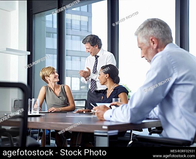 Happy business colleagues having meeting in board room