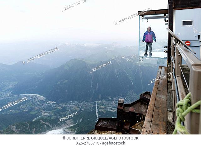 Woman in a crystal box on the void, Pas dans le Vide - step into the void - at 3842 m, Aiguille du Midi, Chamonix-Mont-Blanc, Haute-Savoie, France, Europe