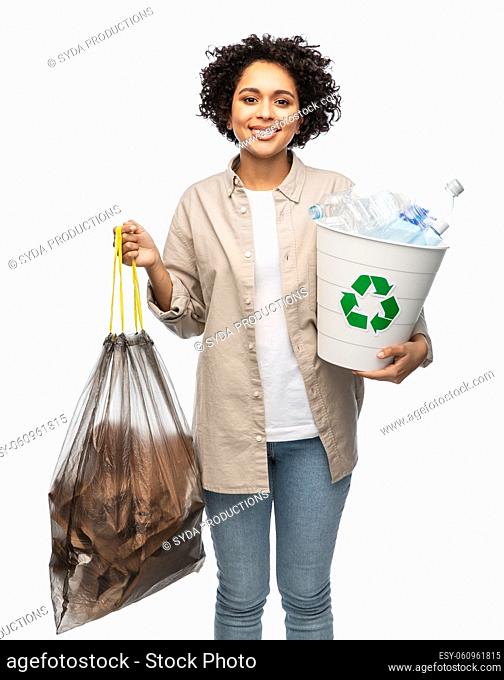 smiling woman sorting plastic and paper waste