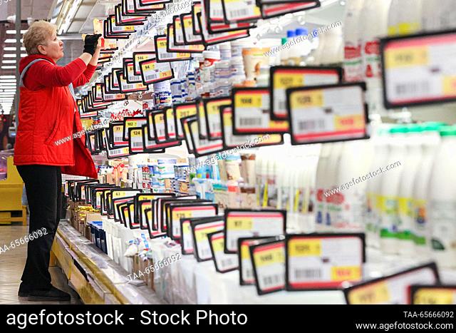 RUSSIA, SIMFEROPOL - DECEMBER 12, 2023: A staff member arranges dairy products on the shelves in the 7M Beztsen superstore during the Christmas season