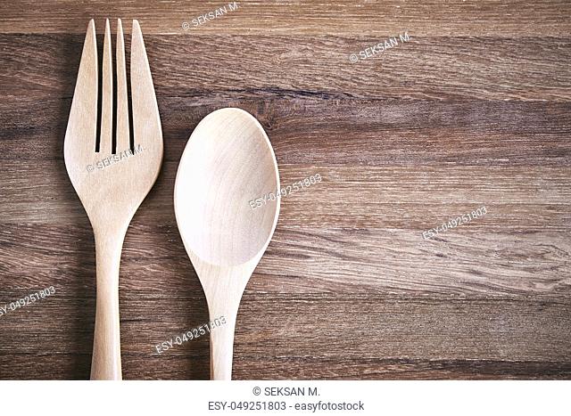 A pair of wooden fork and spoon on the wooden floor with texture