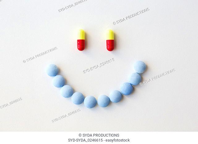 smiley of different pills and capsules of drugs