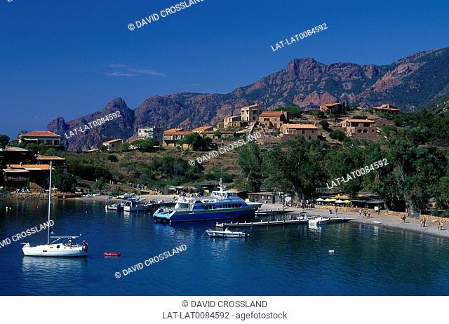 Village on coast. Marina. Large boat, yachts. House, restaurant. Rock cliffs