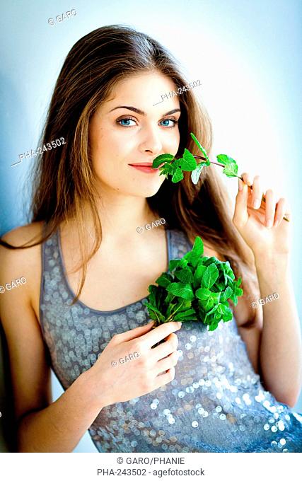 Woman smelling mint leaves Mentha sp.