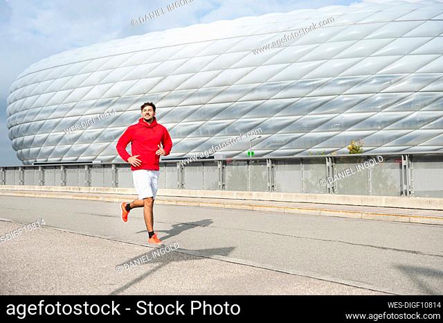 Young man running at Allianz Arena, Munich, Germany